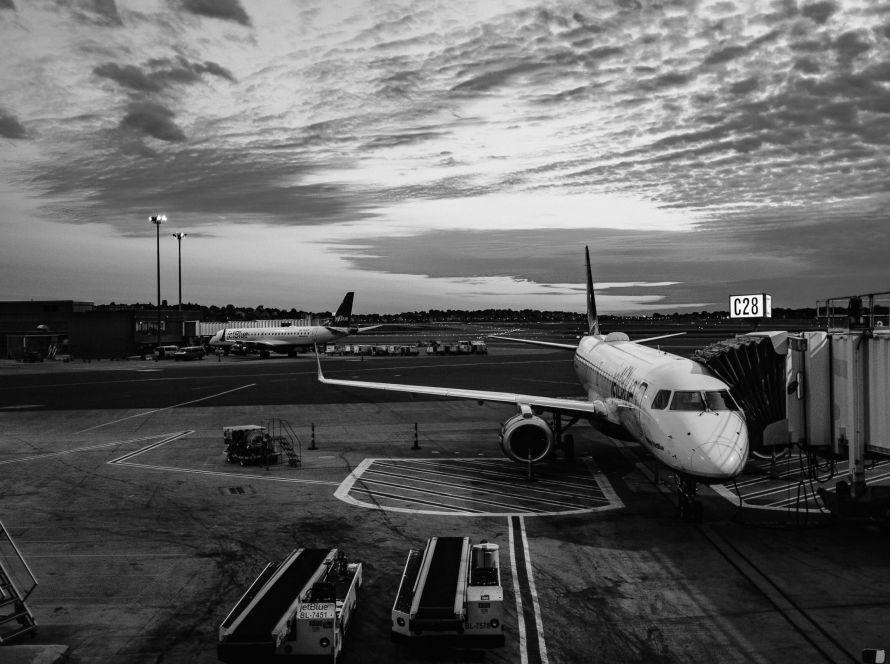 Black and white photo of an airplane parked at the airport, showcasing its sleek design and iconic shape