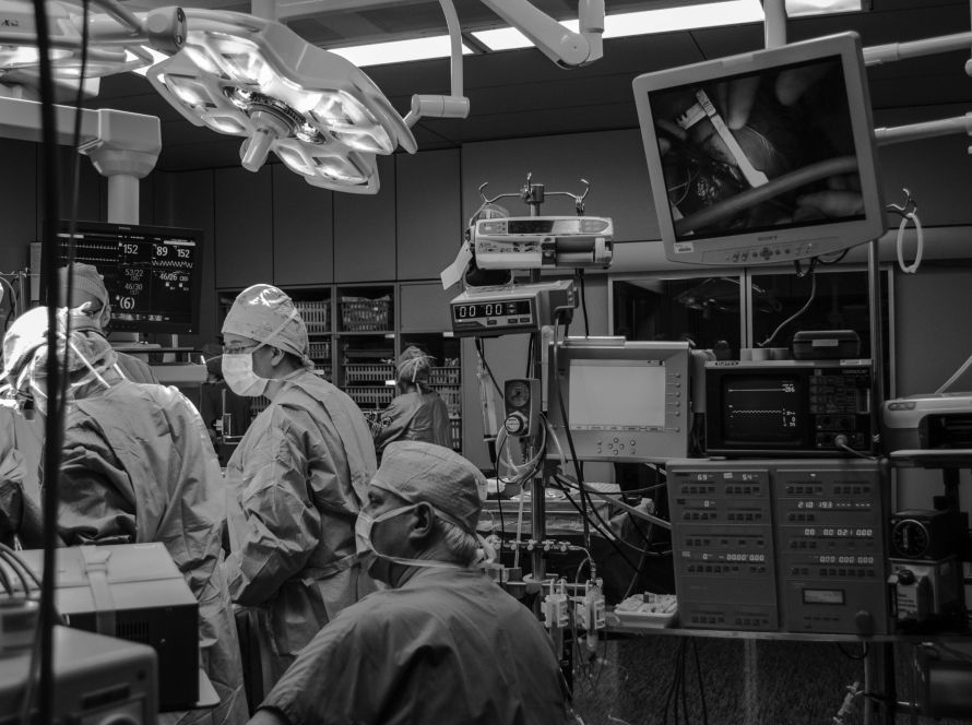 A black and white photo of surgeons performing a surgery in an operating room.